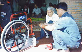 Our oldest member (87 years) in Chiangdao looking on why his new wheelchair is being assembled.